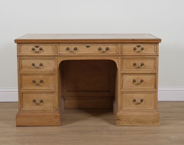 AN EARLY 20TH CENTURY PINE NINE DRAWER KNEEHOLE WRITING DESK