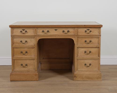 AN EARLY 20TH CENTURY PINE NINE DRAWER KNEEHOLE WRITING DESK