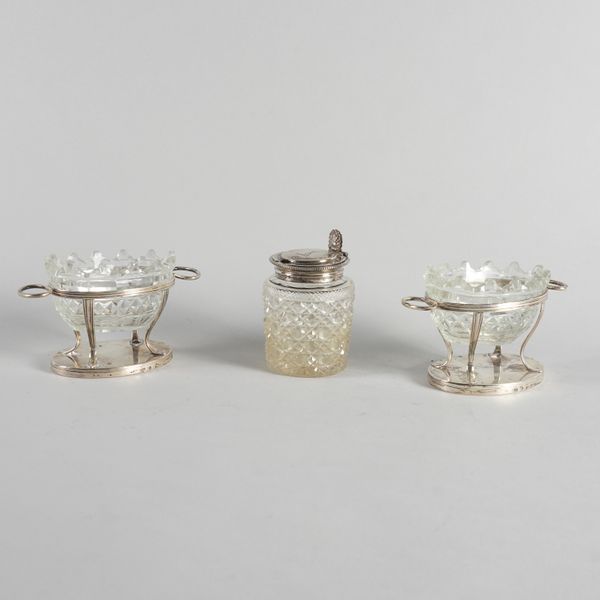 A PAIR OF GEORGE III SILVER TWIN HANDLED SALT FRAMES AND A SILVER MOUNTED GLASS MUSTARD POT (3)