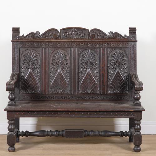 A 17TH CENTURY STYLE CARVED OAK PANEL BACK SETTLE