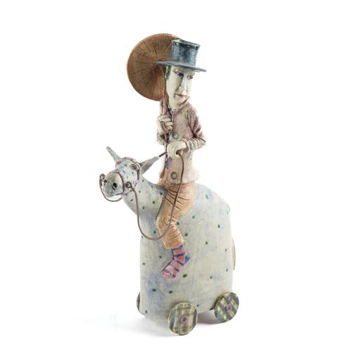 AMANDA POPHAM (BRITISH, B.1954): A STUDIO POTTERY FIGURE OF A MAN WITH PARASOL RIDING A HORSE