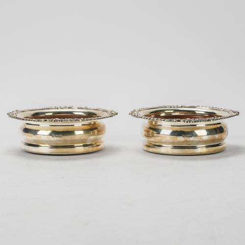 A PAIR OF SILVER MOUNTED BOTTLE COASTERS (2)