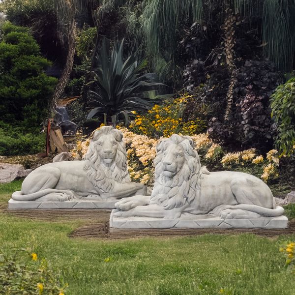 A PAIR OF RECONSTITUTED FIGURES OF RECUMBENT LIONS (2)