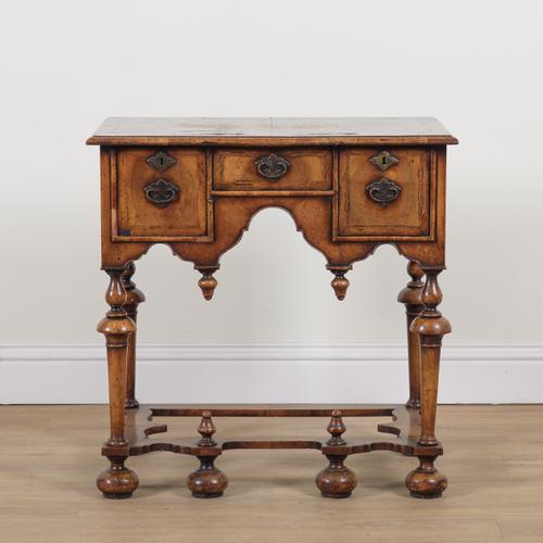 A WILLIAM AND MARY STYLE WALNUT FEATHER BANDED THREE DRAWER LOWBOY