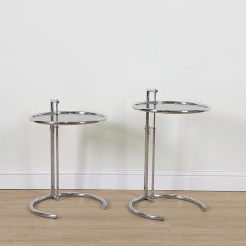 AFTER EILEEN GRAY; A PAIR OF E1027 STYLE CHROME AND SMOKED GLASS CIRCULAR HEIGHT ADJUSTABLE OCCASIONAL TABLES (2)