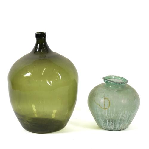 A LARGE GREEN GLASS BOTTLE OR CARBOY AND A SMALLER BULBOUS PALE GREEN GLASS VASE (2)