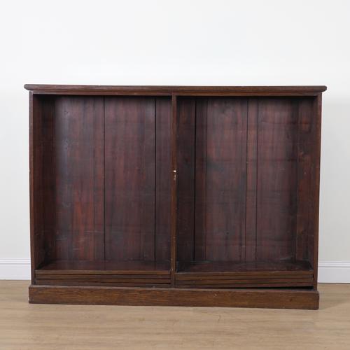 A T JONES LIVERPOOL; AN EARLY 20TH CENTURY OAK FLOOR STANDING TWIN SECTION OPEN BOOKCASE