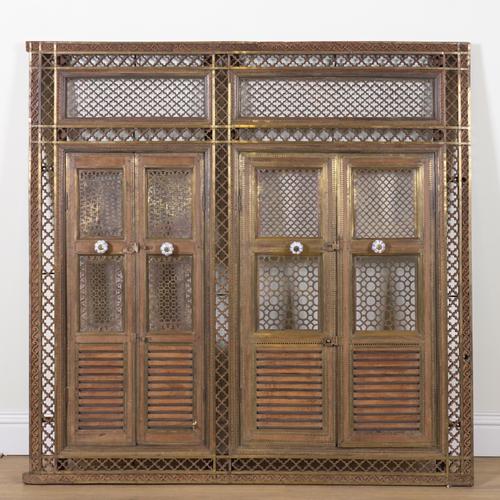 A 19TH CENTURY INDIAN CARVED HARDWOOD AND BRASS MOUNTED DOUBLE JALI SCREEN