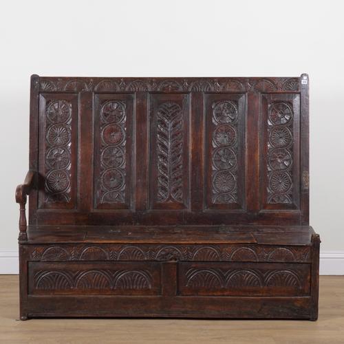 A 17TH CENTURY AND LATER CARVED OAK HIGHBACK SETTLE