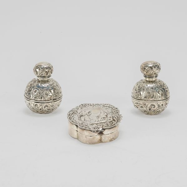A SILVER HINGE LIDDED TRINKET BOX AND A PAIR OF SILVER CASED SCENT BOTTLES (3)