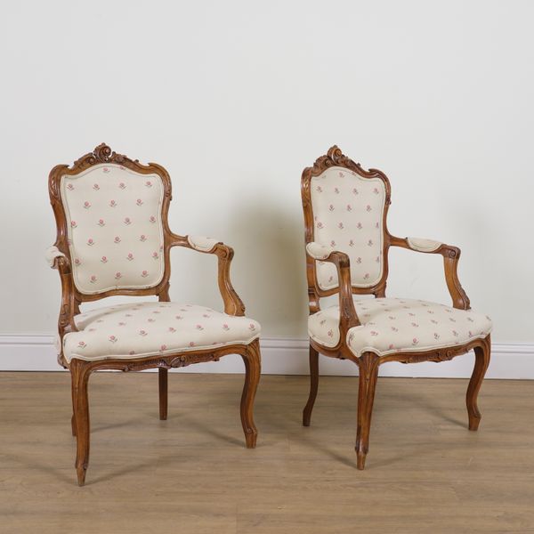 A PAIR OF LOUIS XV STYLE WALNUT FRAMED OPEN ARMCHAIRS (2)