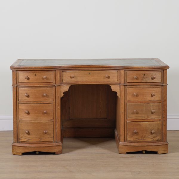 A LATE VICTORIAN ASH SERPENTINE NINE DRAWER WRITING DESK