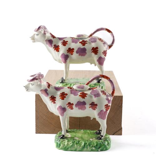 A PAIR OF CAMBRIAN POTTERY COW CREAMERS AND COVERS (4)