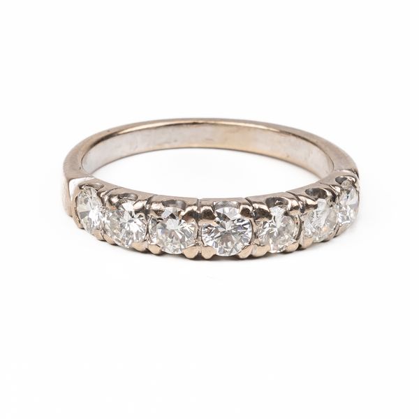 A WHITE GOLD AND DIAMOND SEVEN STONE HALF HOOP RING