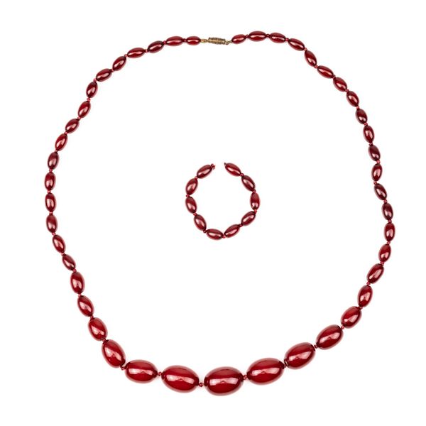 A SINGLE ROW NECKLACE OF GRADUATED CHERRY COLOURED BAKELITE BEADS SIMULATING AMBER