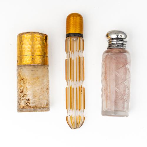 A LATE VICTORIAN 9CT GOLD MOUNTED SMELLING SALTS BOTTLE AND TWO FURTHER GLASS SCENT BOTTLES (3)