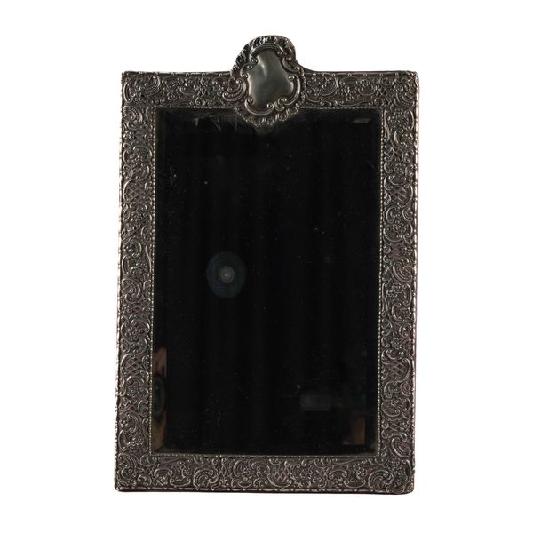 A LATE VICTORIAN SILVER MOUNTED SHAPED RECTANGULAR STRUT BACKED MIRROR