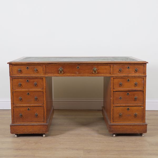 A LATE VICTORIAN OAK NINE DRAWER PEDESTAL DESK