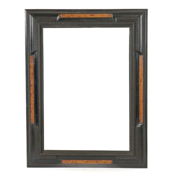 AN ITALIAN EBONISED RIPPLE MOULDED MIRROR