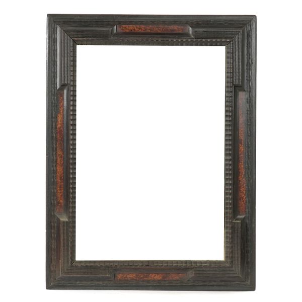 AN ITALIAN EBONISED RIPPLE MOULDED MIRROR