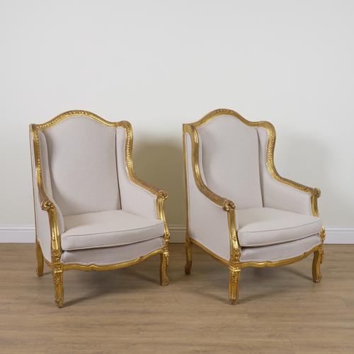 A PAIR OF LOUIS XV STYLE GILT FRAMED WINGBACK ARMCHAIRS (2)
