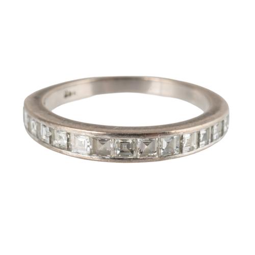 A WHITE GOLD AND STEP CUT DIAMOND HALF ETERNITY RING