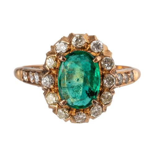 A GOLD, EMERALD AND DIAMOND OVAL CLUSTER RING