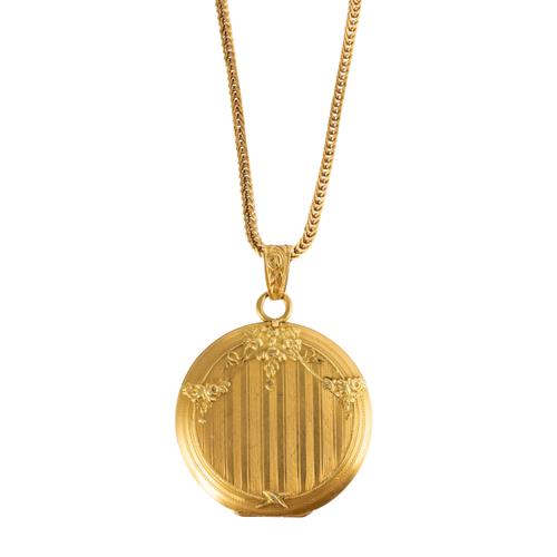A GOLD CIRCULAR LOCKET ON A BOX CHAIN
