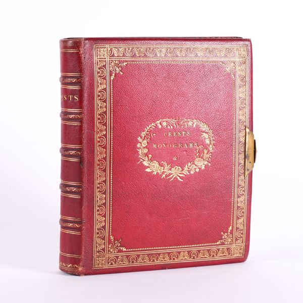 ALBUM - An album of crests, monograms and other decorative armorial devices laid down on c.80 vellum leaves, elaborate painted borders, [mid-late 19th-century], 4to, attractively bound in contemporary red morocco gilt with clasp.