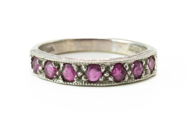 A 9CT WHITE GOLD AND RUBY SEVEN STONE HALF ETERNITY RING