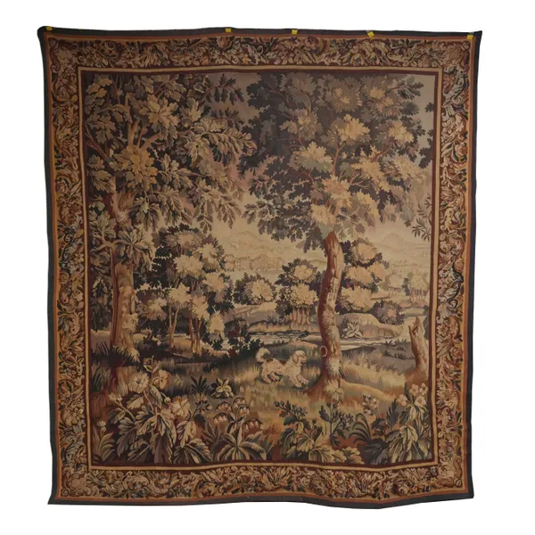 A FRENCH VERDURE TAPESTRY DEPICTING A WOODED SCENE WITH SPANIEL