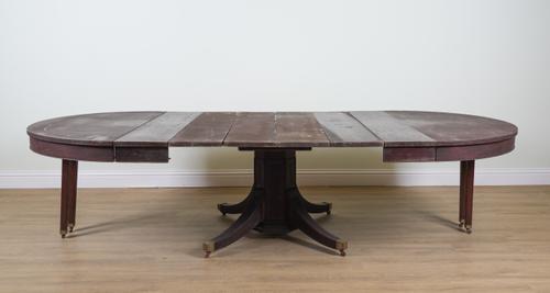 A 19TH CENTURY CONTINENTAL MAHOGANY CIRCULAR EXTENDING DINING TABLE