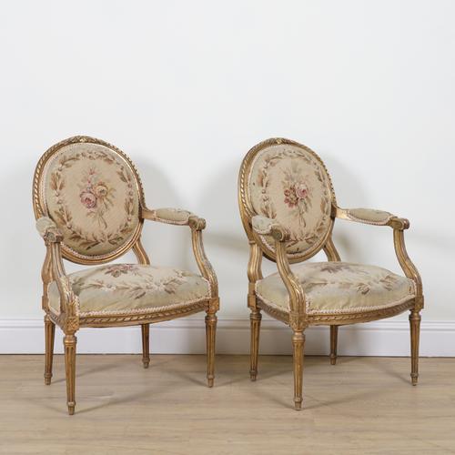 A PAIR OF LOUIS XVI STYLE GILT FRAMED OPEN ARMCHAIRS (2)