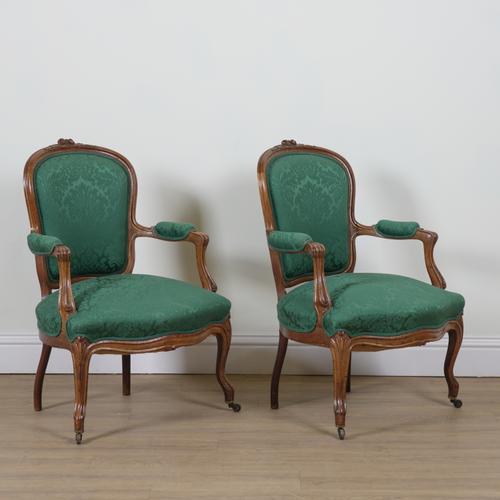 A PAIR OF LOUIS XV STYLE PARCEL GILT WALNUT FRAMED OPEN ARMCHAIRS