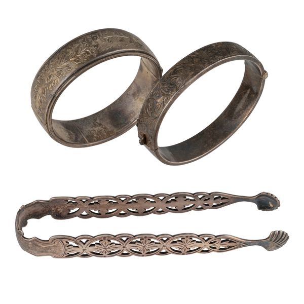 TWO SILVER OVAL HINGED BANGLES AND A PAIR OF VICTORIAN SILVER SUGAR TONGS (3)