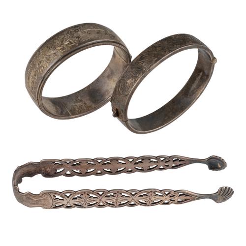 TWO SILVER OVAL HINGED BANGLES AND A PAIR OF VICTORIAN SILVER SUGAR TONGS (3)