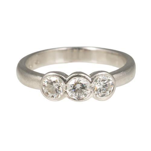 A PLATINUM AND DIAMOND THREE STONE RING