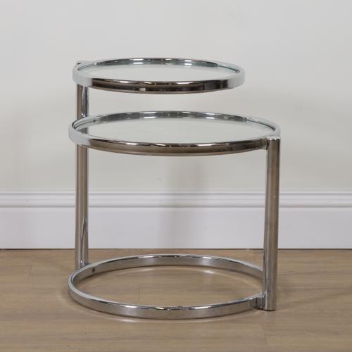 IN THE MANNER OF MILO BAUGHMAN; A CHROME AND GLASS SWIVEL DESIGN TWO TIER COCKTAIL TABLE