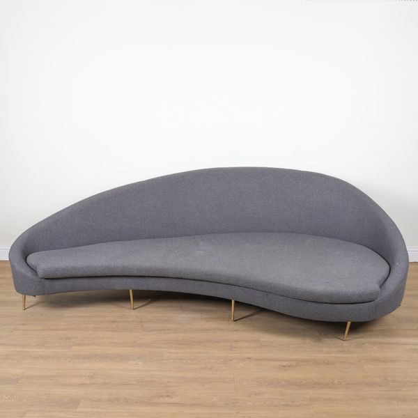 A LARGE CURVED GREY UPHOLSTERED SOFA