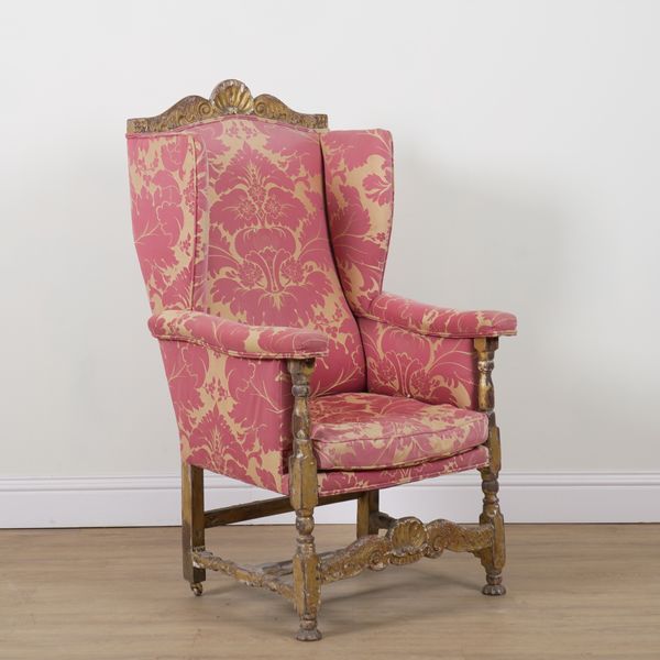 A CONTINENTAL GILT CARVED WINGBACK ARMCHAIR