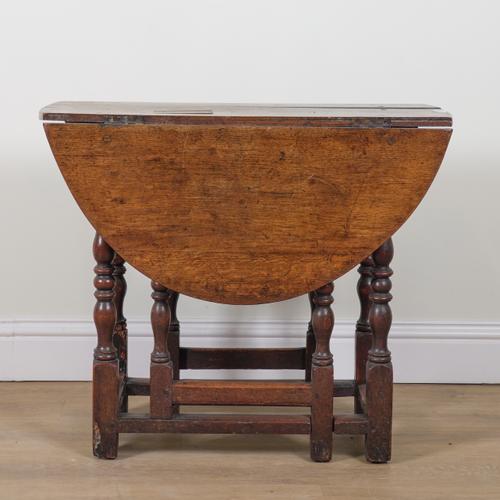 AN 18TH CENTURY OAK OVAL DROP FLAP GATELEG TABLE