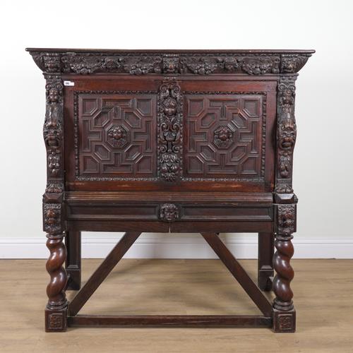 A 17TH CENTURY AND LATER CARVED OAK CABINET ON STAND
