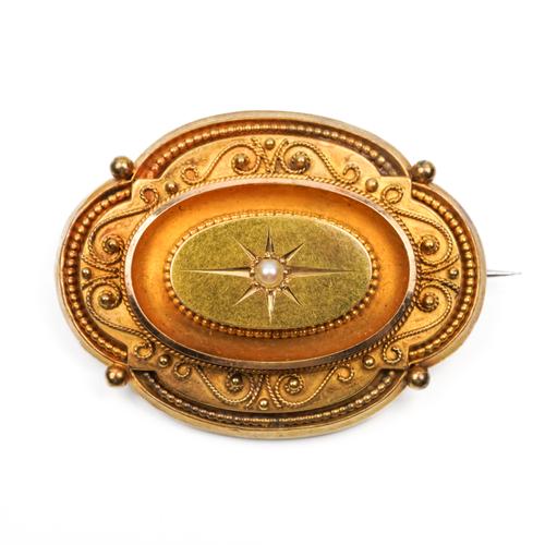 A VICTORIAN GOLD AND HALF PEARL SHAPED OVAL BROOCH