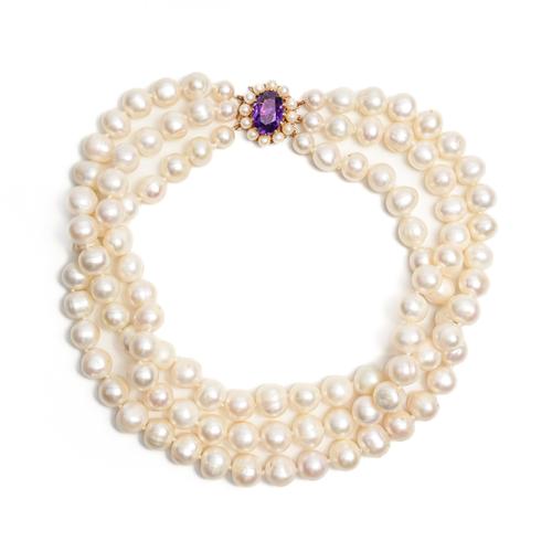 A THREE STRAND CULTURED PEARL NECKLACE WITH LARGE AMETHYST CLASP