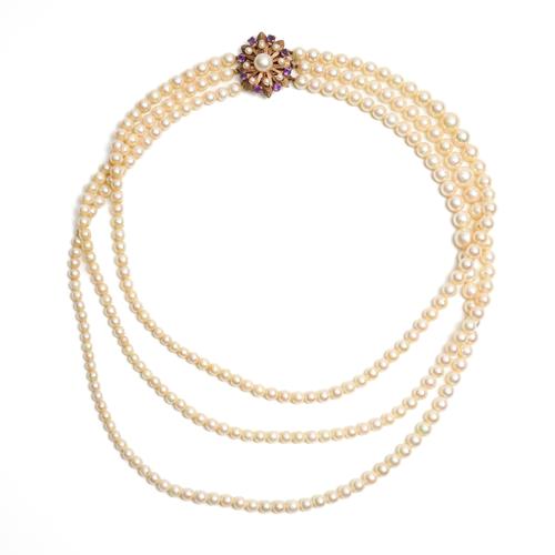 A THREE STRAND CULTURED PEARL NECKLACE WITH PEARL AND AMETHYST CLASP