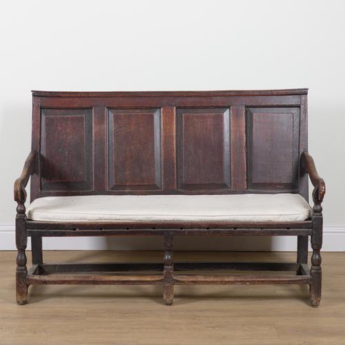AN 18TH CENTURY OAK FOUR PANEL BACK OPEN ARM SETTLE