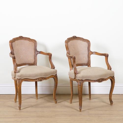 A PAIR OF LOUIS XV STYLE CARVED AND STAINED BEECH FRAMED OPEN ARMCHAIRS (2)