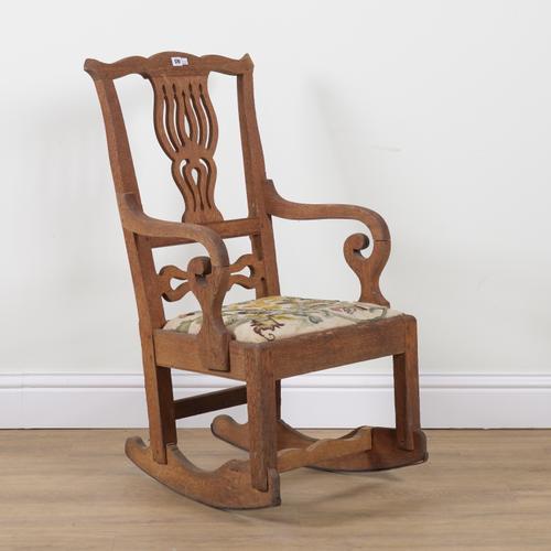 AN EARLY 19TH CENTURY STRIPPED OAK ROCKING CHAIR