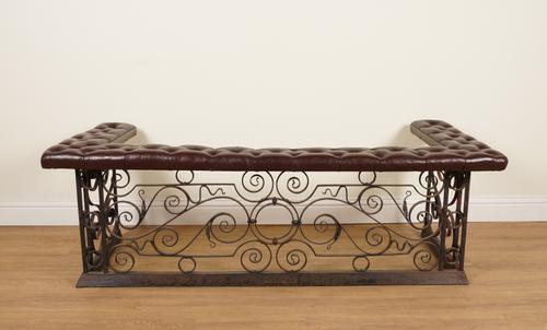 A WROUGHT IRON AND BURGUNDY BUTTON-DOWN LEATHER CLUB FENDER