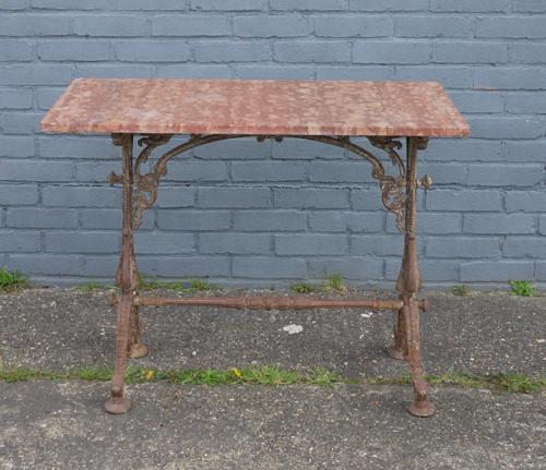 A RECTANGULAR ROUGE MARBLE TOPPED GARDEN TABLE ON FOLIATE CAST METAL BASE